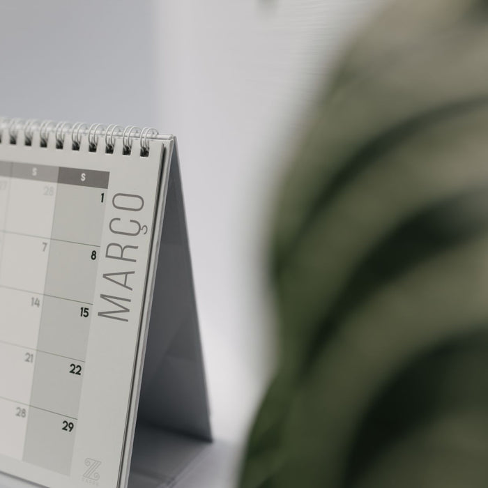 A close-up shot of a desk calendar open on March, with a soft, minimalistic background.