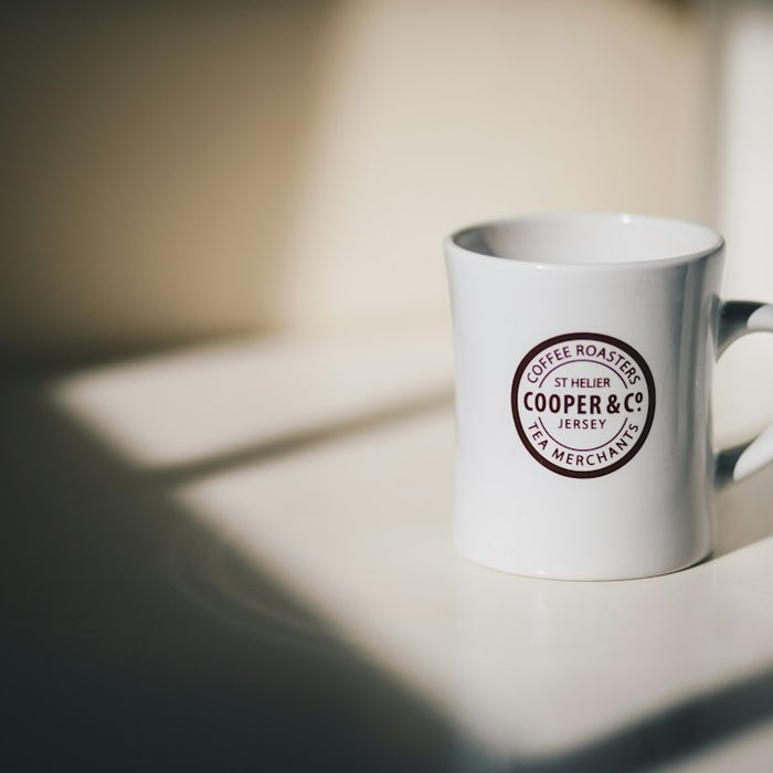 selective focus photo of white mug on white surrface