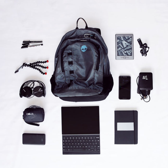 flat lay photography of backpack, laptop computer, headphones, smartphone, and octopus tripod