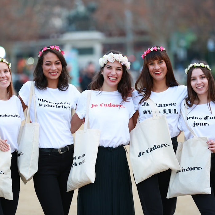 women in white shirts with bags