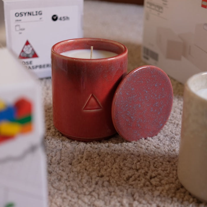 2 red pillar candles on gray textile