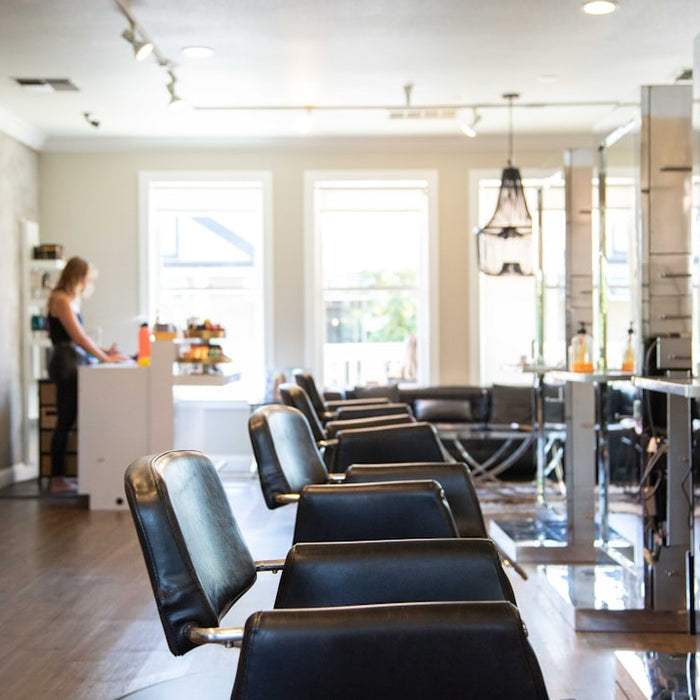 woman in white shirt standing near black leather chairs