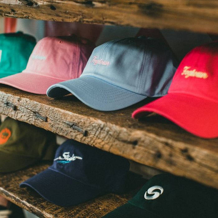 a row of hats sitting on top of a wooden shelf