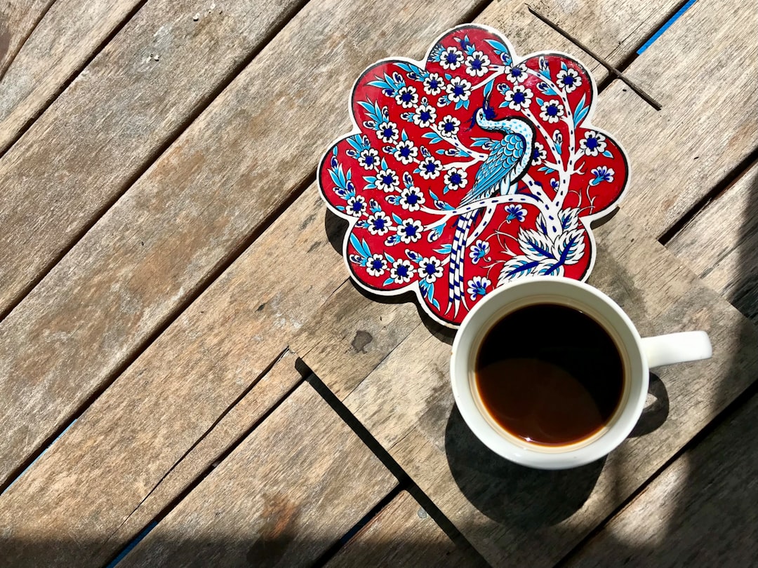 a cup of coffee sitting on top of a wooden table