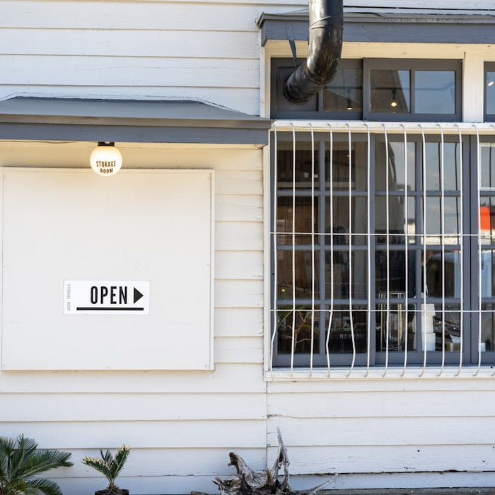 a white building with a window and a sign on it