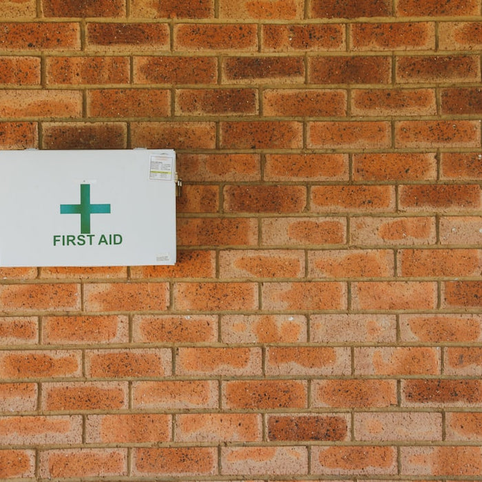 a first aid sign on a brick wall