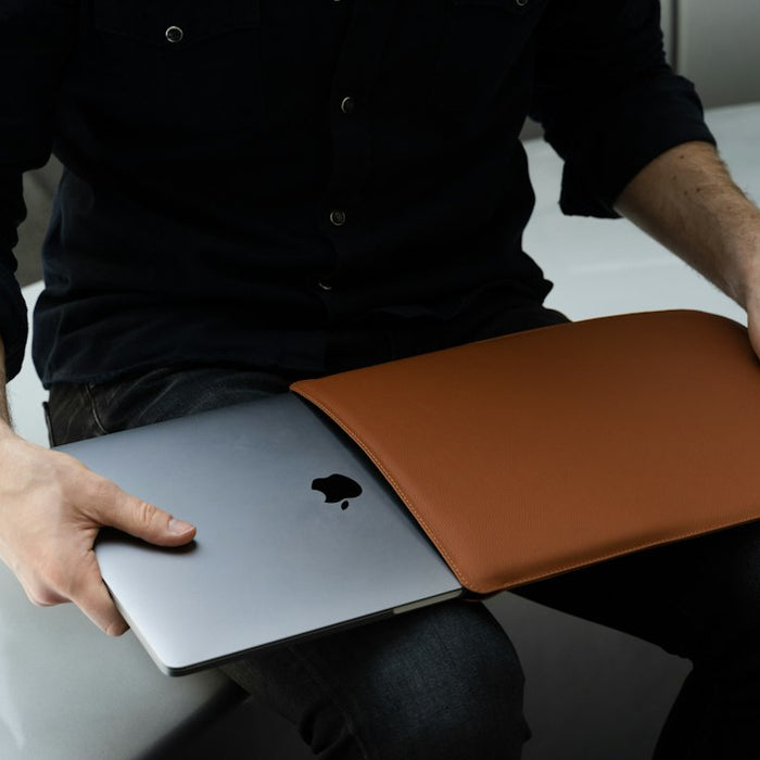a man sitting on a chair holding a laptop