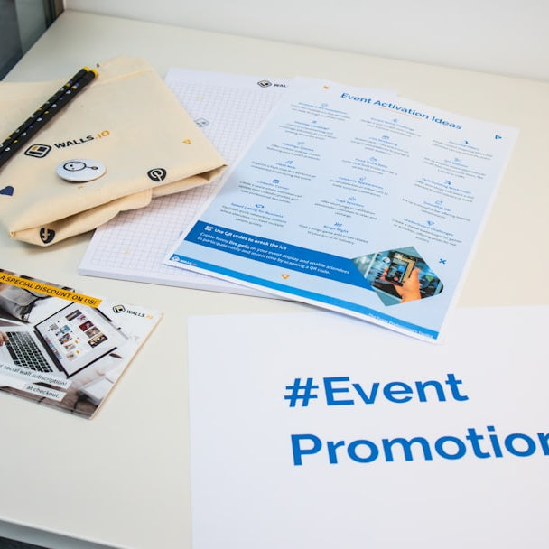 a table with a brochure, magazine, and pen on it