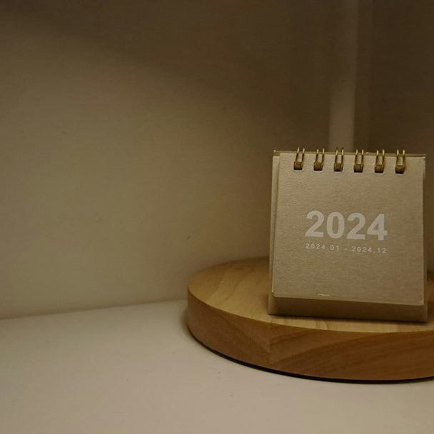 A desk lamp with a calendar on top of it
