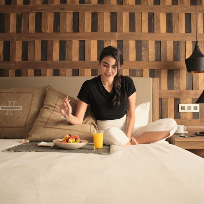 A woman sitting on a bed in a hotel room
