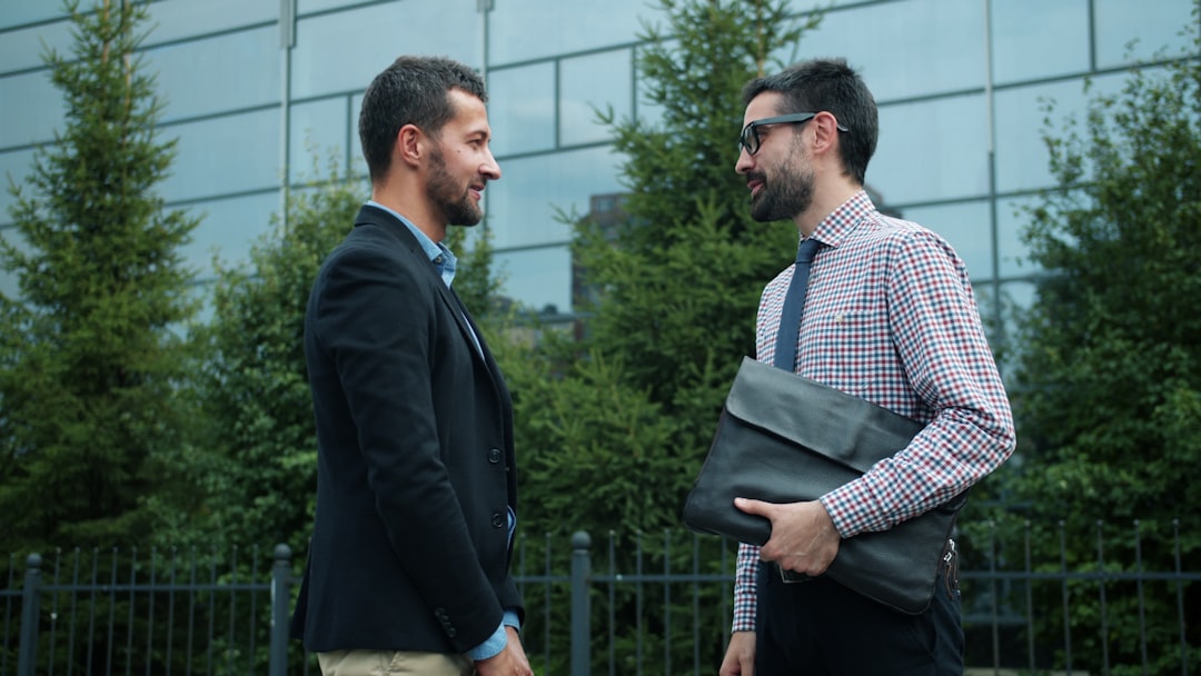 Two businessmen talking outside modern building