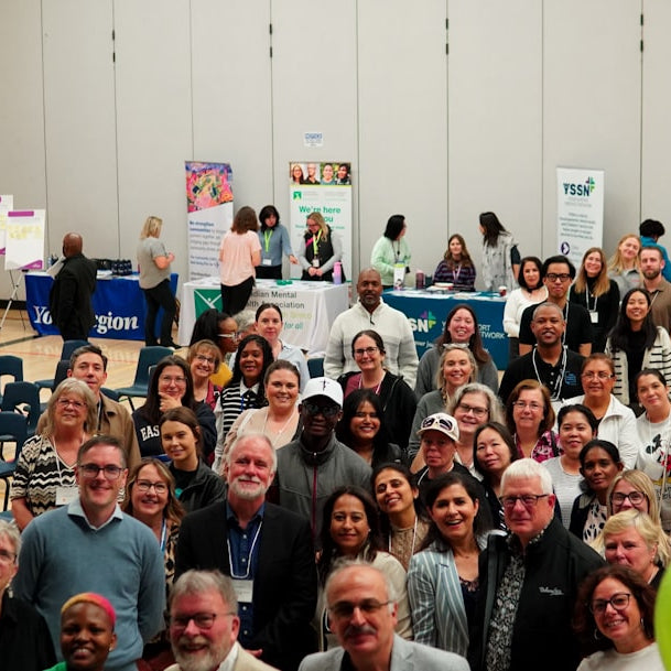 A large group of people gathered indoors at an event.