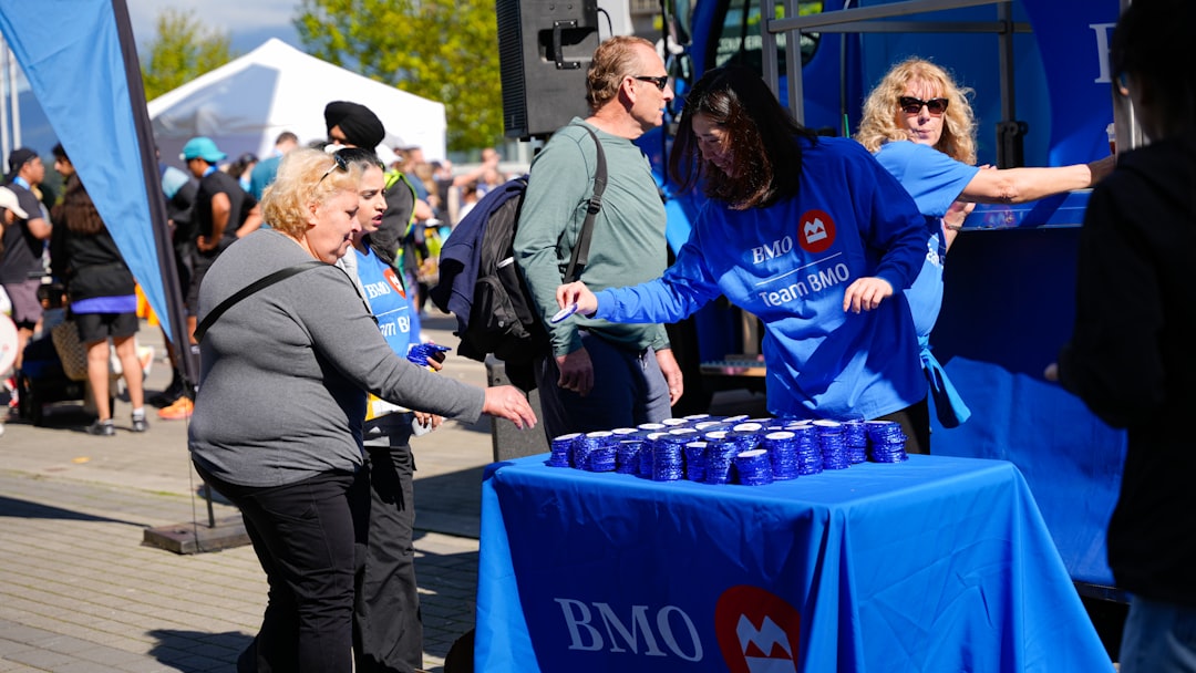 People receiving drinks from a table at an outdoor event.