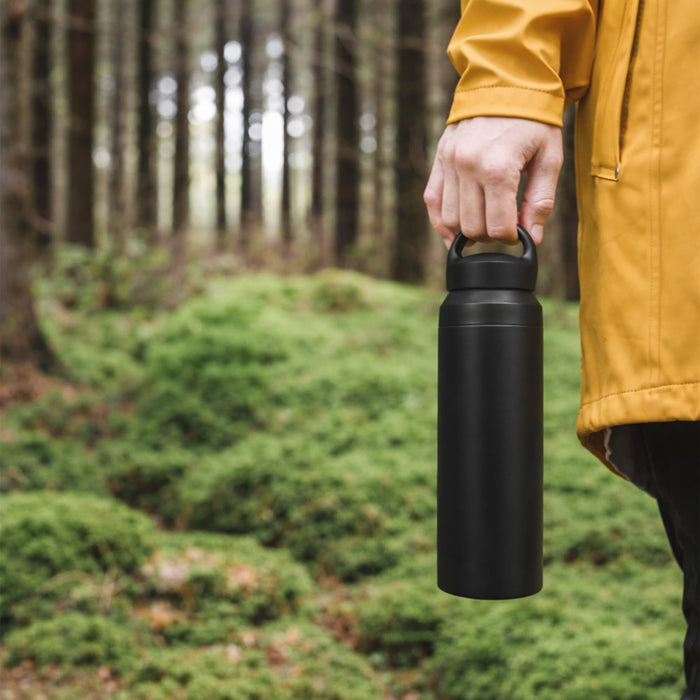 350ML/500ML Double Wall Stainless Steel Drink Bottle with Handle - A drink bottle in matte black, featuring a handle, held by a person in a yellow jacket amidst a forested background.