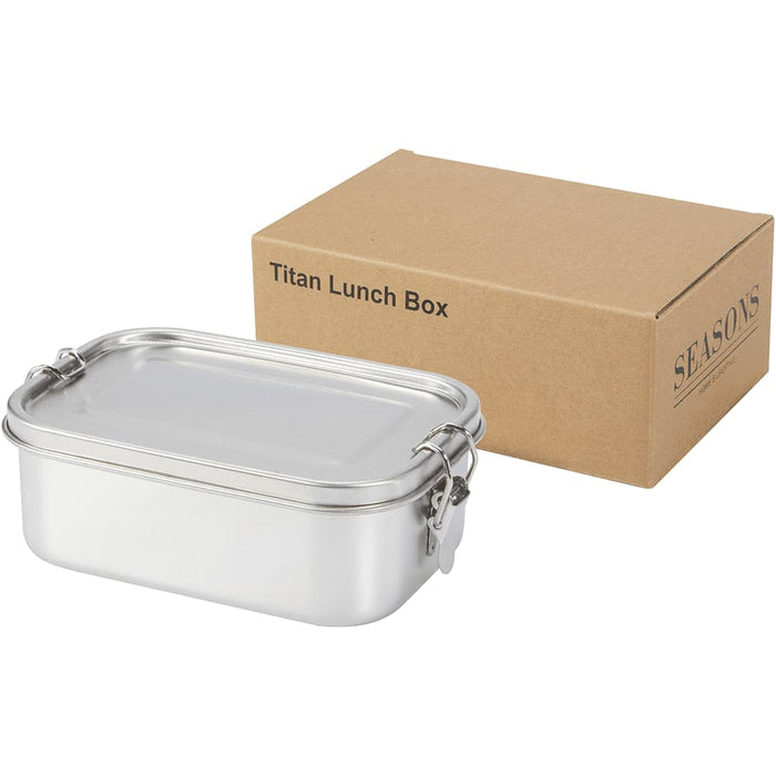 Seasons Titan Recycled Stainless Steel Lunch Box - A stainless steel lunch box with a clear lid beside a rectangular cardboard box, featuring branding.