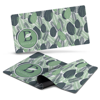 Desk Mat - A desk mat featuring a leafy green design with various shades of green and a circular logo.