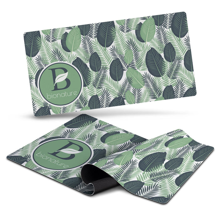 Desk Mat - A desk mat featuring a leafy green design with various shades of green and a circular logo.