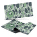 Desk Mat - A desk mat featuring a leafy green design with various shades of green and a circular logo.