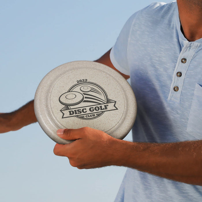 Choice Flyer - Large - A person holds a large grey disc with a disc golf design and logo, wearing a light blue shirt.