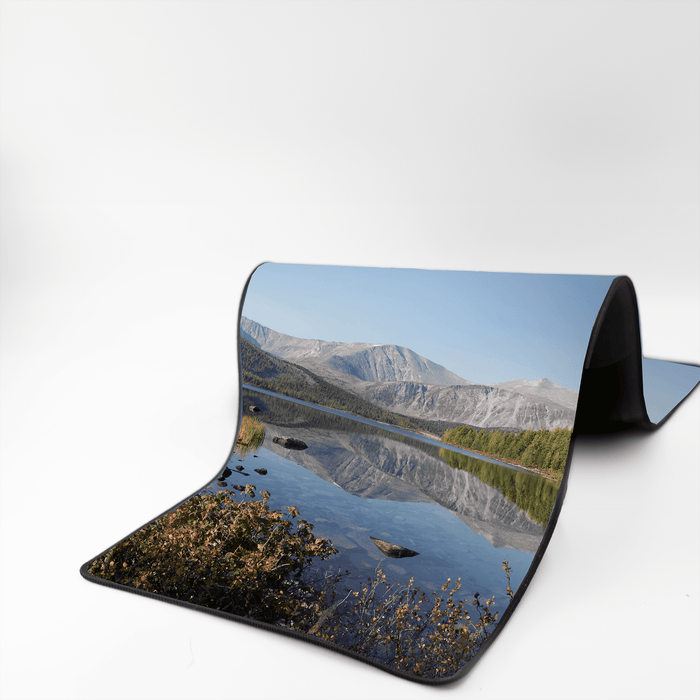 Rubber Desk Mat - A rubber desk mat featuring a scenic landscape with mountains and a calm lake, predominantly in shades of blue and green.