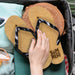 Fiji Flip Flops - A pair of black and tan Fiji flip flops resting on a travel bag alongside a straw accessory.