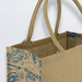 Lanza Jute Tote Bag - A jute tote bag featuring a natural beige colour with a blue design and sturdy handles. It has branding on the side.