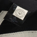 Essence Organic Cap - A black and grey cap made from organic cotton, featuring a tag with a logo and care instructions.