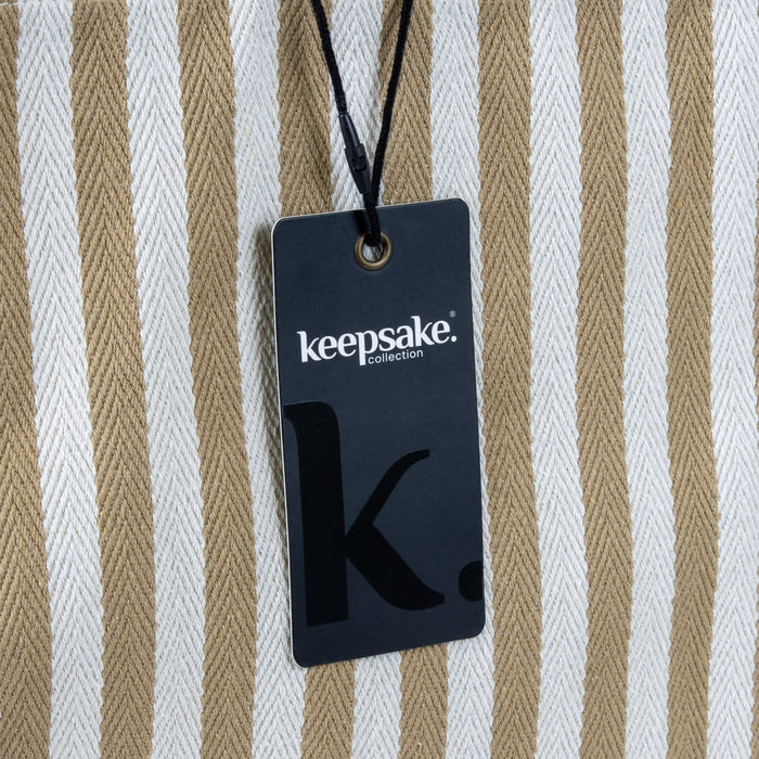 Keepsake Beach Tote Bag - A striped beach tote bag in cream and tan, featuring a tag with a logo attached.