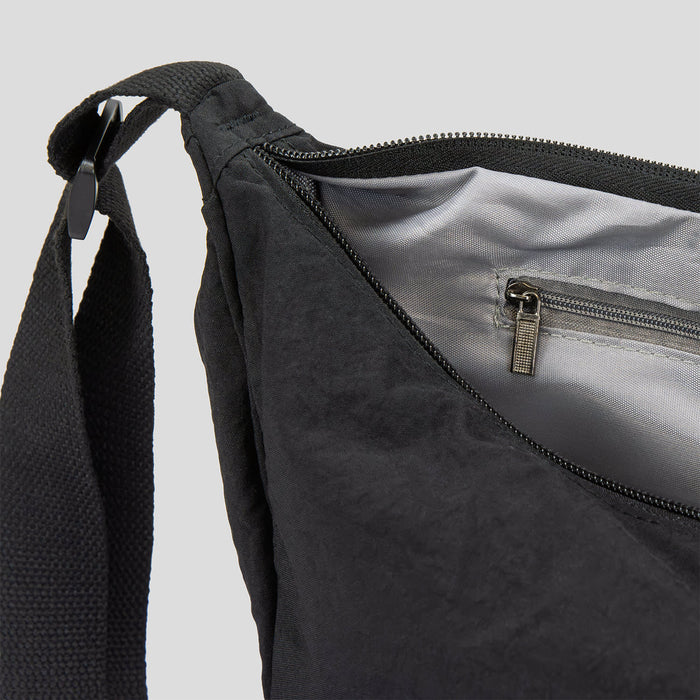 Selene Moon Bag - A black bag with a zippered opening and an interior pocket, featuring a sturdy strap. It has a simple, sleek design.