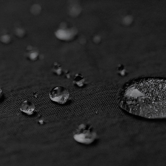 Byron 14" GRS Recycled City Laptop Backpack 16L - A close-up of water droplets on a textured black fabric, highlighting its water-resistant properties.