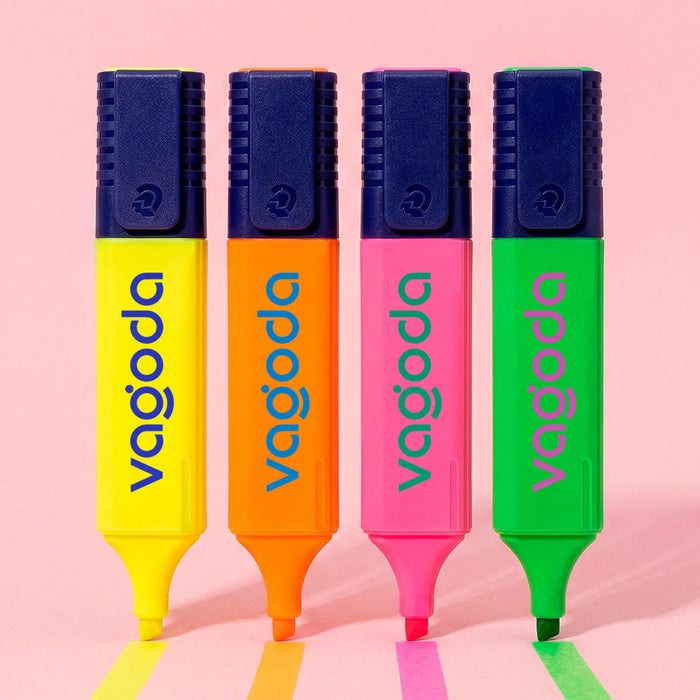 Staedtler Textsurfer Classic Highlighter - Four highlighters in yellow, orange, pink, and green with a logo on each, resting on a pink surface.