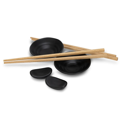 Keepsake Sushi Set - A sushi set featuring black ceramic plates, wooden chopsticks, and small dipping bowls.