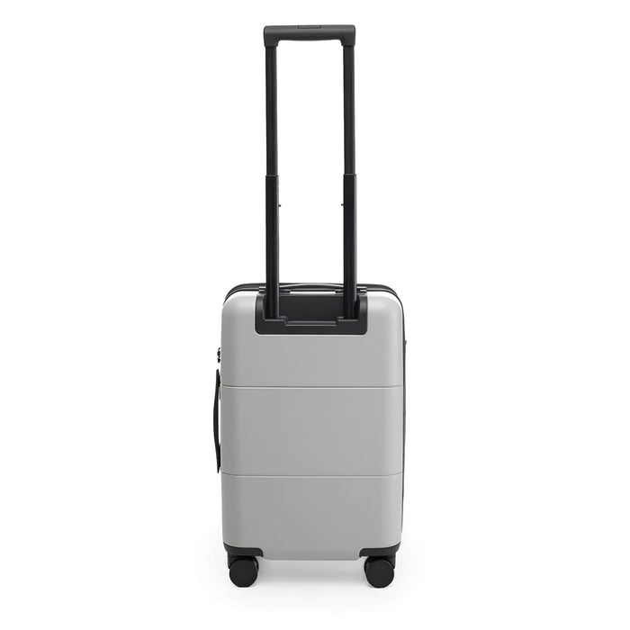 Kadi Carry-On Suitcase - Leisure - A silver carry-on suitcase with a retractable handle and wheels, featuring a simple design and a logo.