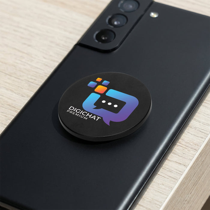 Multi-Functional Magnetic Badge - A black magnetic badge with a colourful logo sits on the back of a smartphone, placed on a wooden surface.