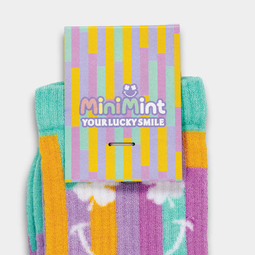 Pixel Knitted Bamboo Socks - A pair of turquoise and purple knitted bamboo socks with a tag, featuring a colourful striped design.