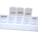 Weekly Pill Organiser - A white weekly pill organiser with clear compartments for each day of the week, featuring lids for easy access.