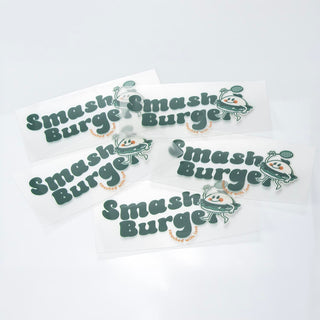 Prism Print - 100 x 50mm Sticker - A collection of green and white stickers featuring a playful logo and branding for "Smash Burger."