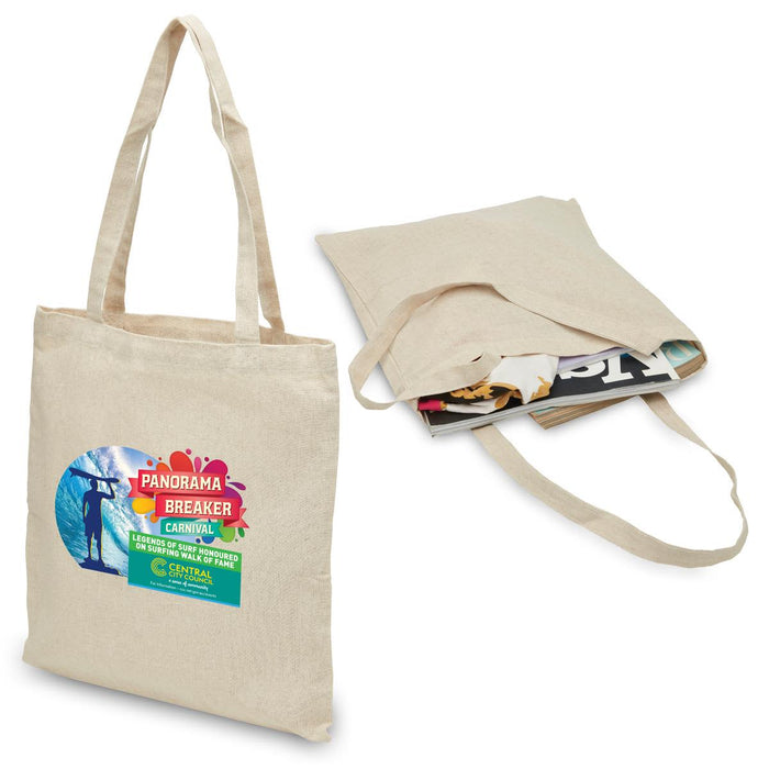 Hemp Tote - A beige hemp tote bag with two handles, featuring a logo and filled with magazines.