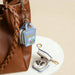 Mini PU Leather Jewellery Box - A mini blue PU leather jewellery box, open to reveal jewellery, attached to a brown bag. Features a logo.