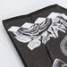 8inch Bamboo Fabric Hand Fan - A bamboo fabric hand fan in black with white floral designs and a slim, folded structure. It features branding.