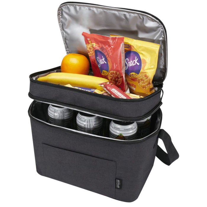 Tundra GRS RPET Double Compartment Cooler Bag 13L - A double compartment cooler bag in charcoal grey, containing snacks, fruit, and drink cans. It has a logo and an unzipped lid.