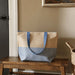 Paper Straw Large Zipped Tote - 21L - A large zipped tote bag in a natural and blue colour scheme, featuring sturdy handles and a spacious design.