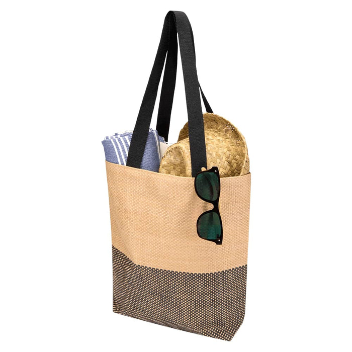 Paper Straw Tote Bag - 10L - A beige and black tote bag with black straps, containing a towel and a straw hat, and sunglasses resting on the bag.