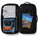 Rime Backpack - A black backpack opened to reveal a grey shirt, blue jeans, a camera, an umbrella, and travel guides.