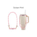 Silicone Flower Tumbler Strap - A drink bottle with a cream coloured body, paired with a pink silicone flower tumbler strap and gold clips.