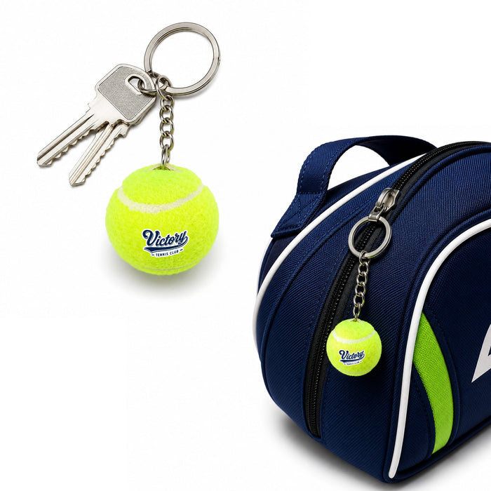 Tennis Ball Keyring - A bright yellow tennis ball keyring attached to a chain and a set of keys, alongside a blue sports bag.