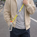2 in 1 Water Bottle Lanyard - A drink bottle with a bright yellow lanyard is held by a person wearing a beige hoodie in an outdoor setting.