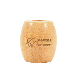 Bamboo Toothbrush Stand - A bamboo toothbrush stand in a light wood colour with a logo on the front.