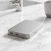 Quantum Pro Power Bank w/ Semi-Solid State Battery 5000mAh - A silver power bank with a sleek design, featuring USB ports, resting on a marble surface.