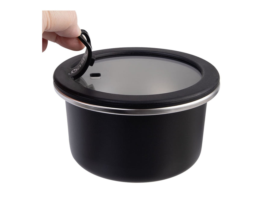 Oasis Microwave Safe Round S/S Container 680ml - A round, black stainless steel container with a clear lid and a handle. Features a sleek design and reflects modern styling.